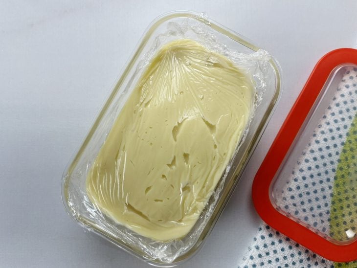 Um recipiente contendo recheio de limão sem leite condensado, coberto com papel filme.