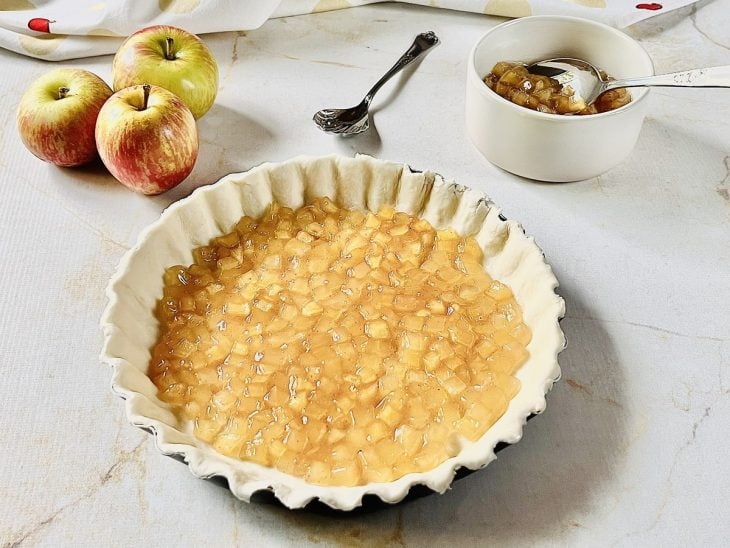 Recheio de maçã sobre uma massa de torta doce.