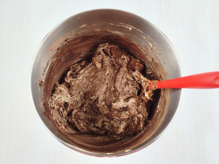 Cacau em pó sendo incorporado delicadamente ao creme.