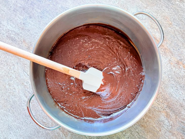 Creme de chocolate sendo mexido no fogo até ganhar brilho e consistência.