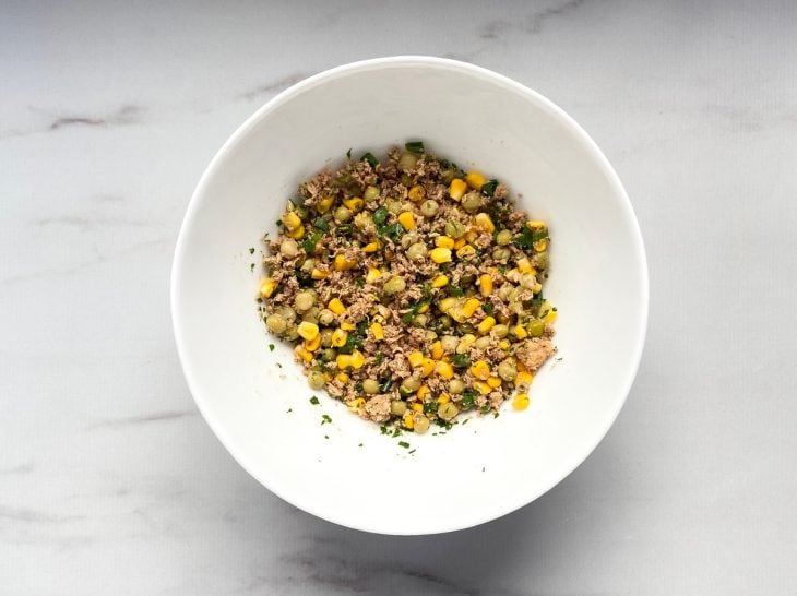 Um recipiente contendo legumes coziods e picados