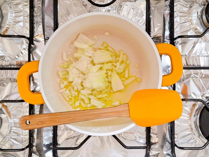 Azeite e cebola picada numa panela.