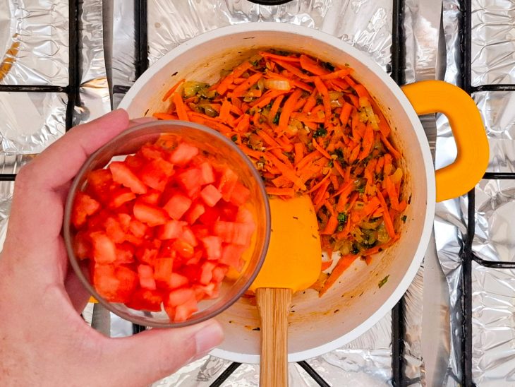 Cenoura e tomate adicionados na panela já cortados.