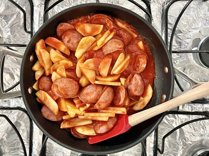 Batatas e molho de tomate adicionado na panela.