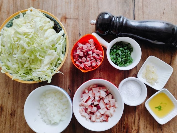 Ingredientes separados para a receita de repolho refogado com bacon e calabresa.