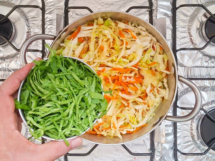 Couve sendo adicionada na panela.