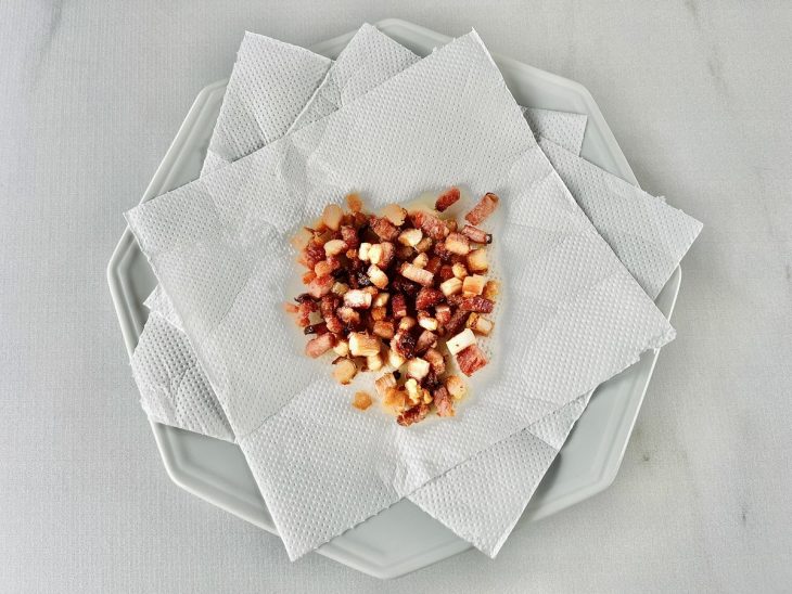 Bacon frito em um prato com papel-toalha.