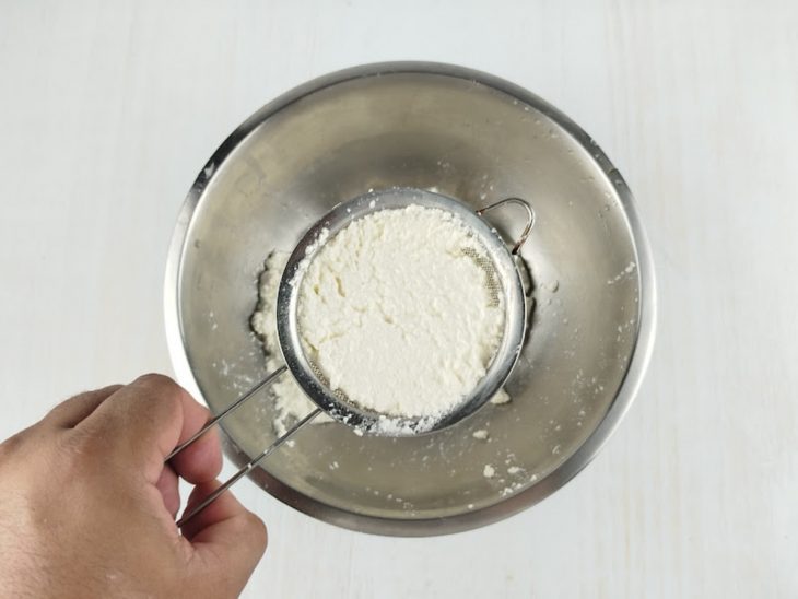 Coalhada sendo peneirada para separar o soro.