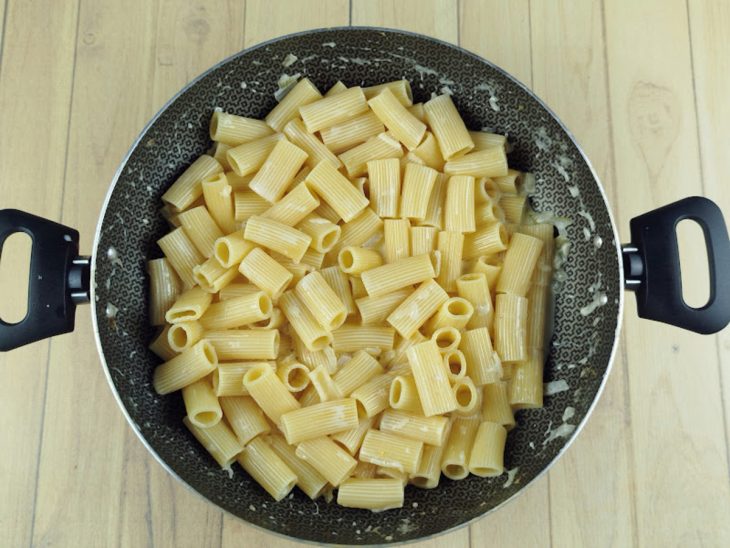 Rigatoni colocado na frigideira com molho.