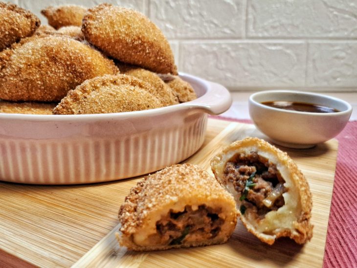 Recipiente com risoles de carne moída.