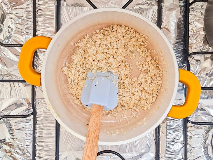 Em outra panela, o arroz tostando.