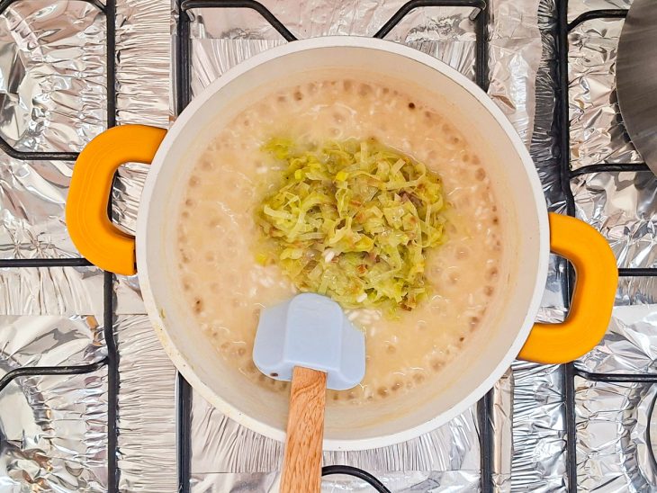 Alho-poró sendo adicionado na panela do arroz.