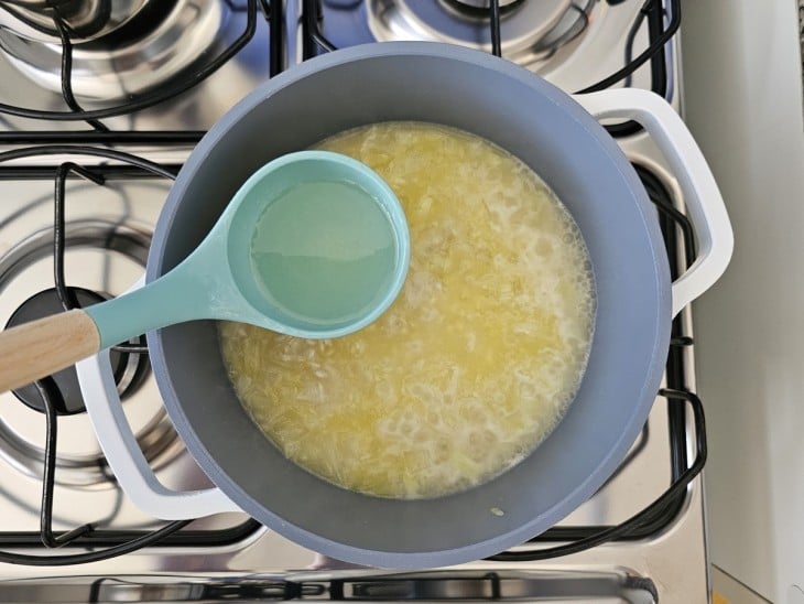 Uma panela com arroz e caldo de legumes.