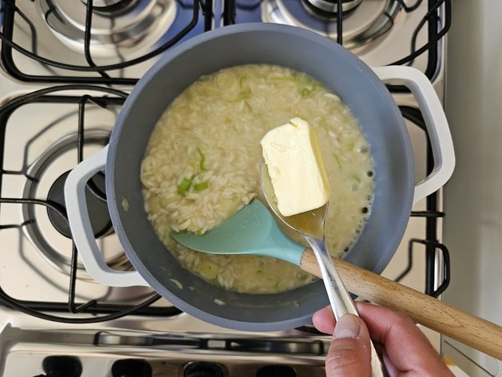 Uma panela com risoto e manteiga.