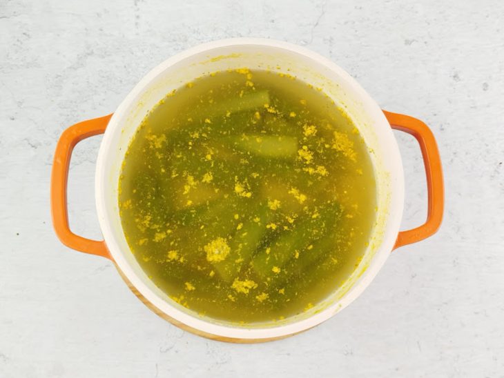 Água e caldo de legumes adicionados na panela.