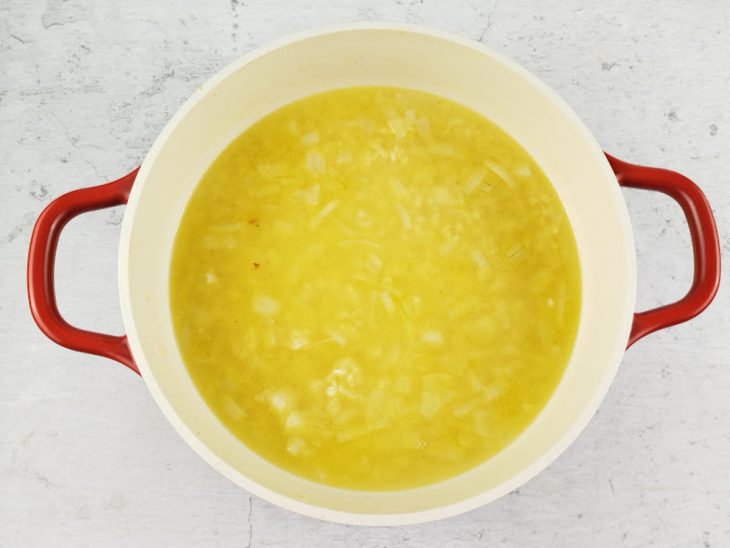 Caldo de legumes sendo adicionado ao arroz.