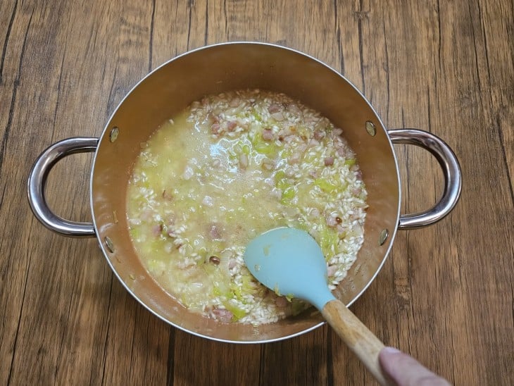 Panela com risoto e caldo para cozinhar.