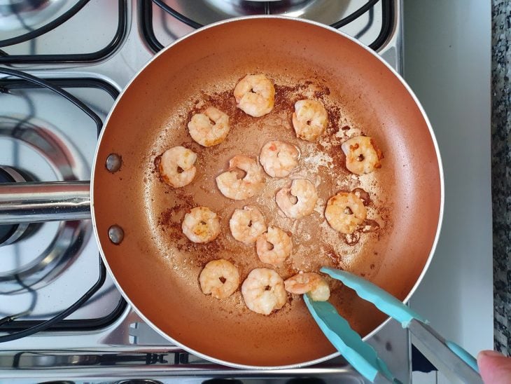 Uma frigideira com camarões fritos.