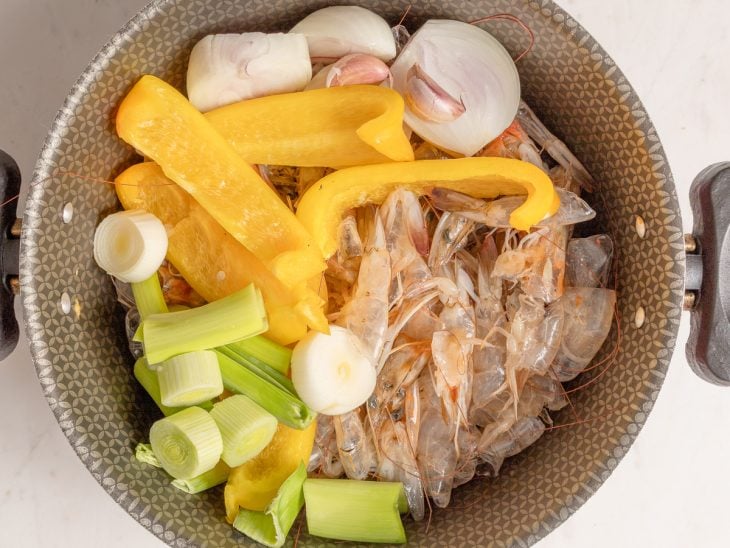 Ingredientes para o caldo de camarão em uma panela.