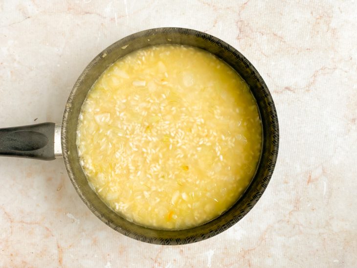Caldo de legumes adicionado a panela com arroz.
