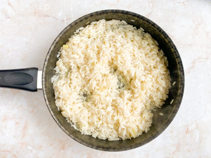 Caldo de camarão adicionado à panela de arroz.
