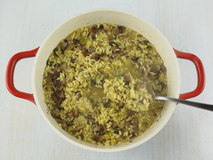 Risoto cozinhando até os grãos ficarem macios e o preparo adquirir textura cremosa.