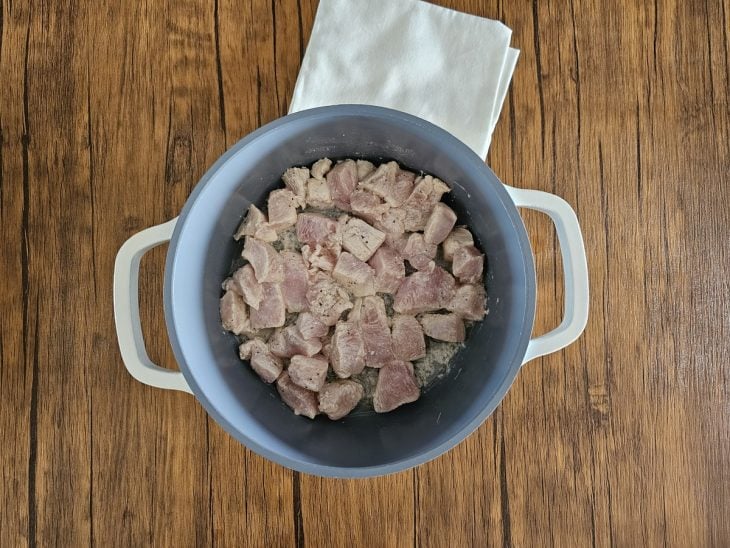 Uma panela refogando os cubos de frango.