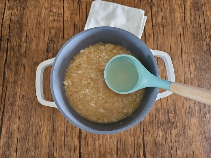 Uma panela cozinhando arroz arbóreo com caldo de legumes.