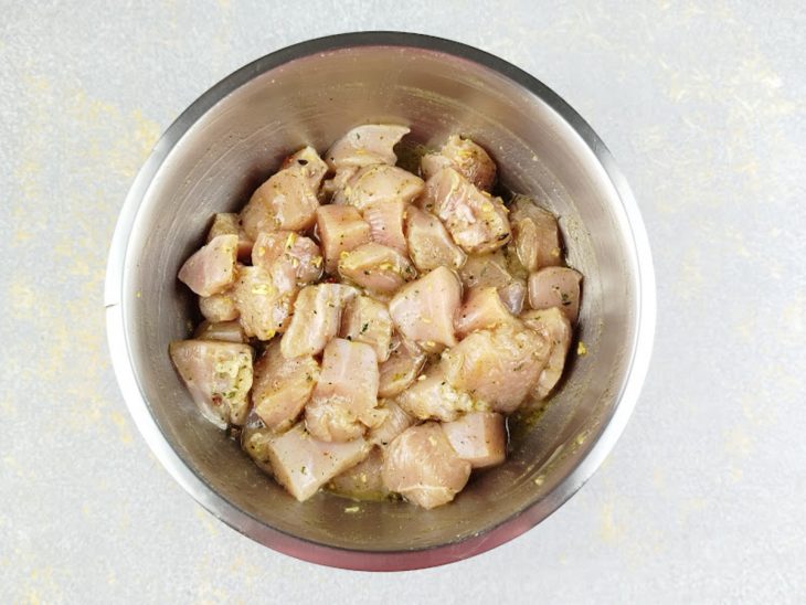 Cubos de frango temperados numa tigela redonda.