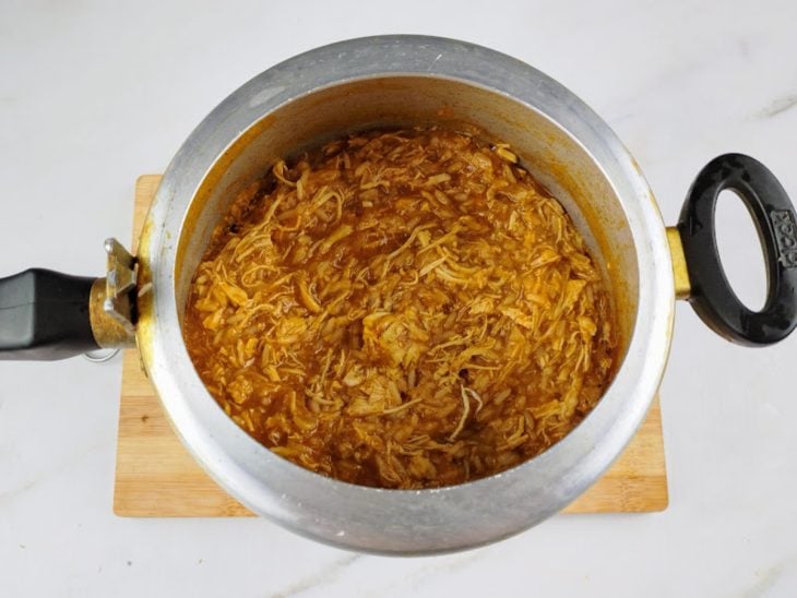 Molho de tomate, caldo do cozimento e arroz adicionados na panela de pressão.