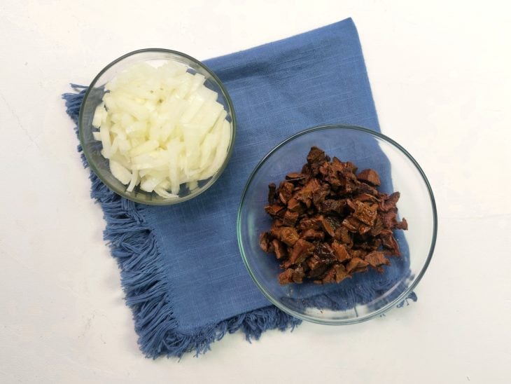 Recipientes com cogumelo e cebola picados.