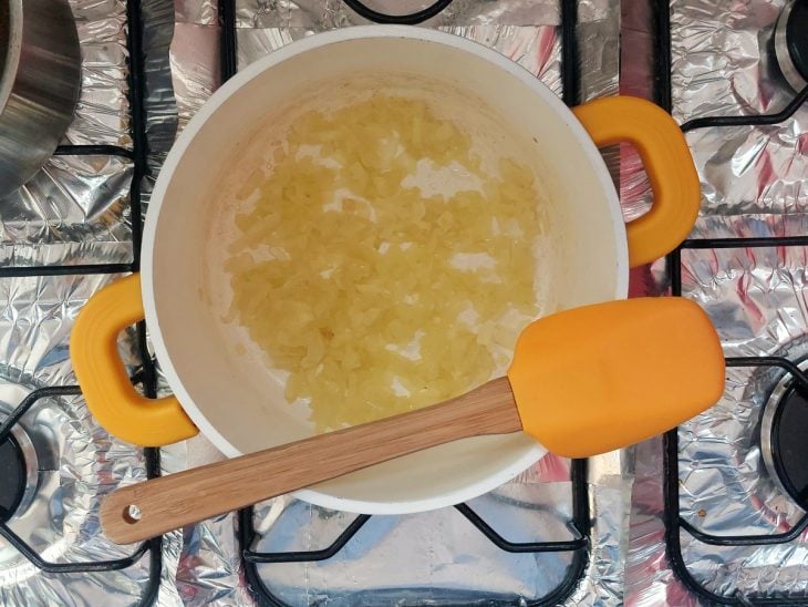 Uma panela com cebola refogada.