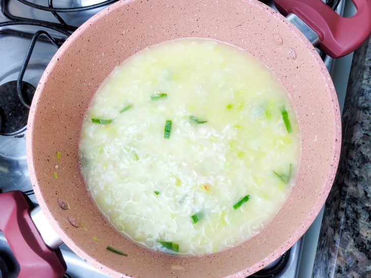 Uma panela contendo arroz refogado com caldo de legumes.