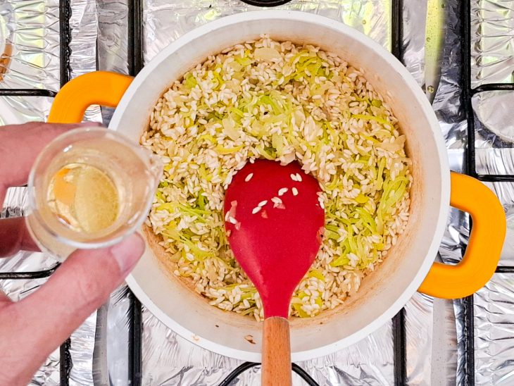 Arroz arbóreo e vinho branco seco adicionado a panela.
