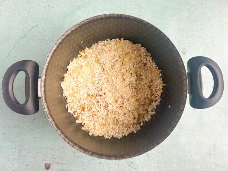 Arroz arbório adicionado na panela.
