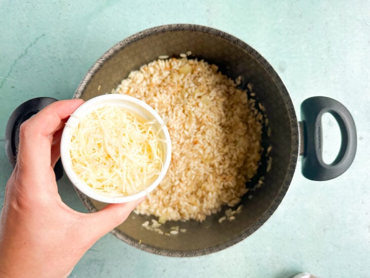 Parmesão sendo adicionado na panela.