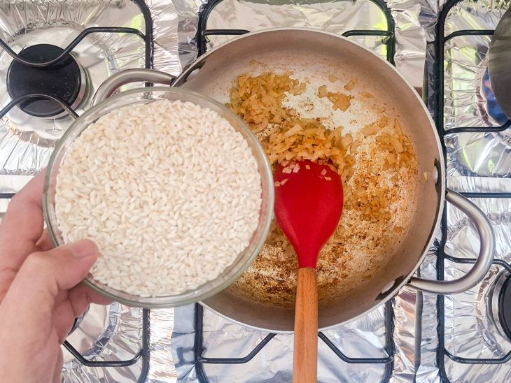 Arroz arbóreo sendo adicionado à panela.