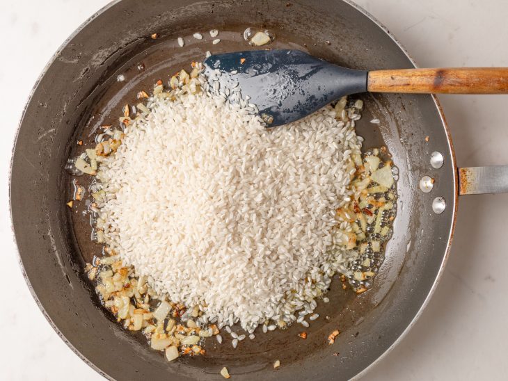 Arroz a sal adicionados a frigideira.