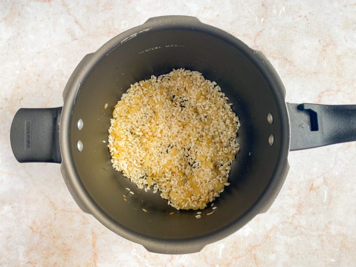 Arroz arbóreo adicionado a panela de pressão.