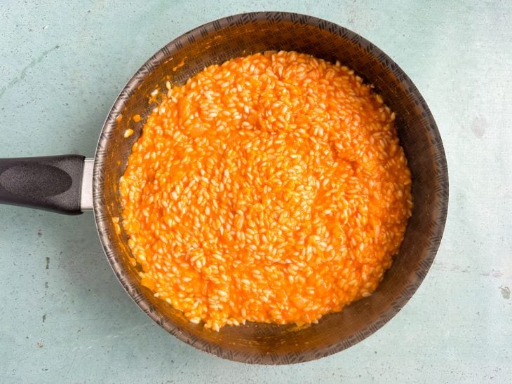 Mistura do liquidificador adicionada na panela do arroz.