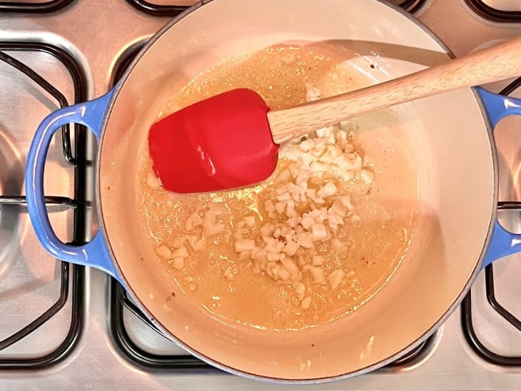 Uma panela refogando a cebola na manetiga.