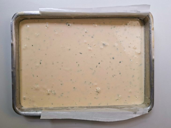 Mistura do liquidificador despejada na forma com papel manteiga.