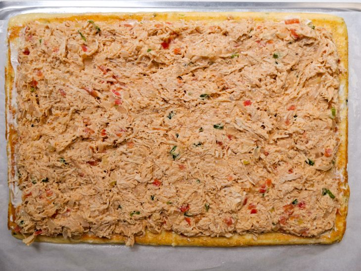 Frango acomodado sobre a camada de requeijão.