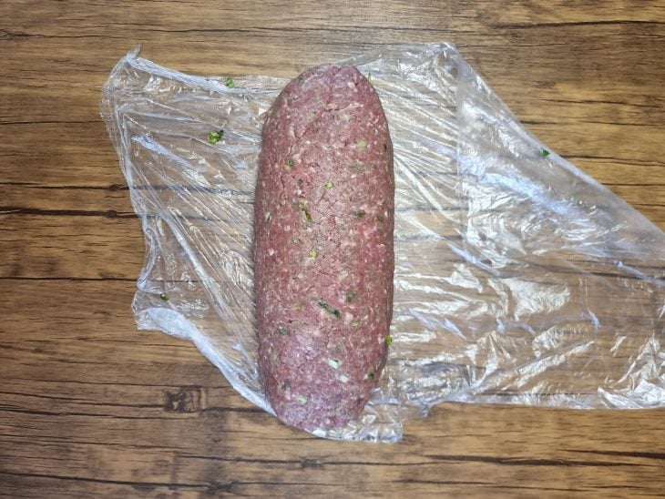 Rolo de carne moída em cima do plástico.