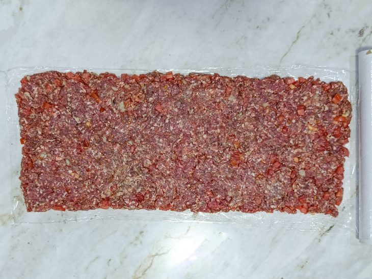 Carne aberta sobre um pedaço de plástico filme.