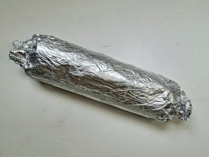 Rocambole enrolado e fechado com papel-alumínio.