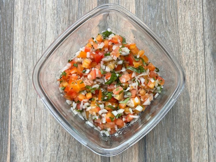 Uma tigela com tomate, a cebola e a salsinha.