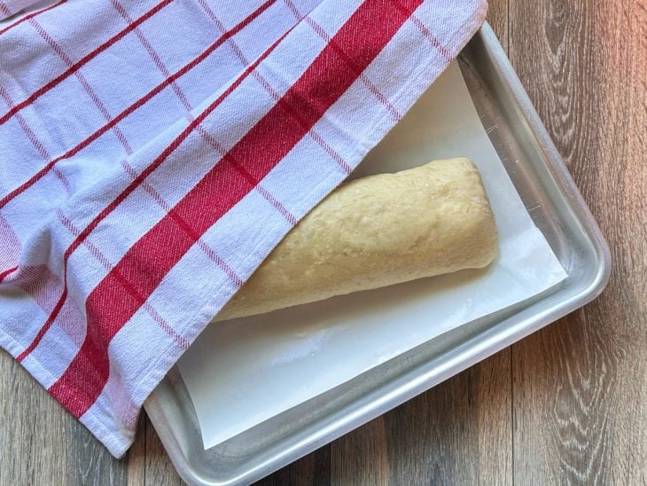Uma forma com rocambole coberto com pano.