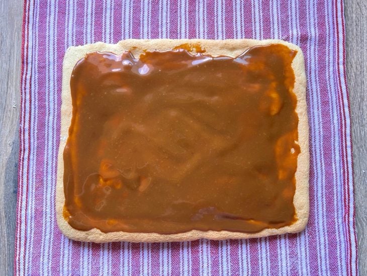 Massa do rocambole com uma camada de doce de leite.