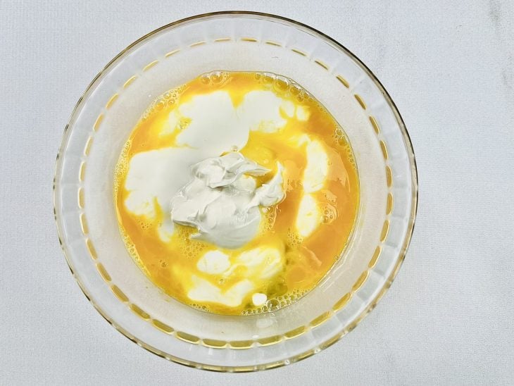 Tigela com ovos, requeijão e creme de leite.